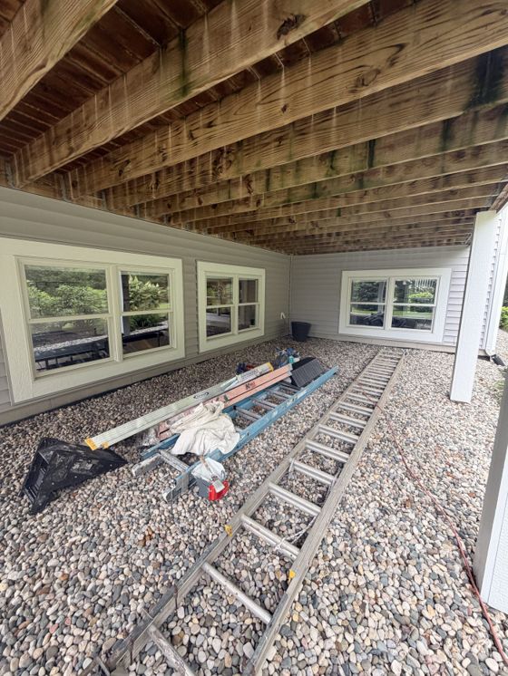 A row of freshly cleaned basement windows beneath a raised deck