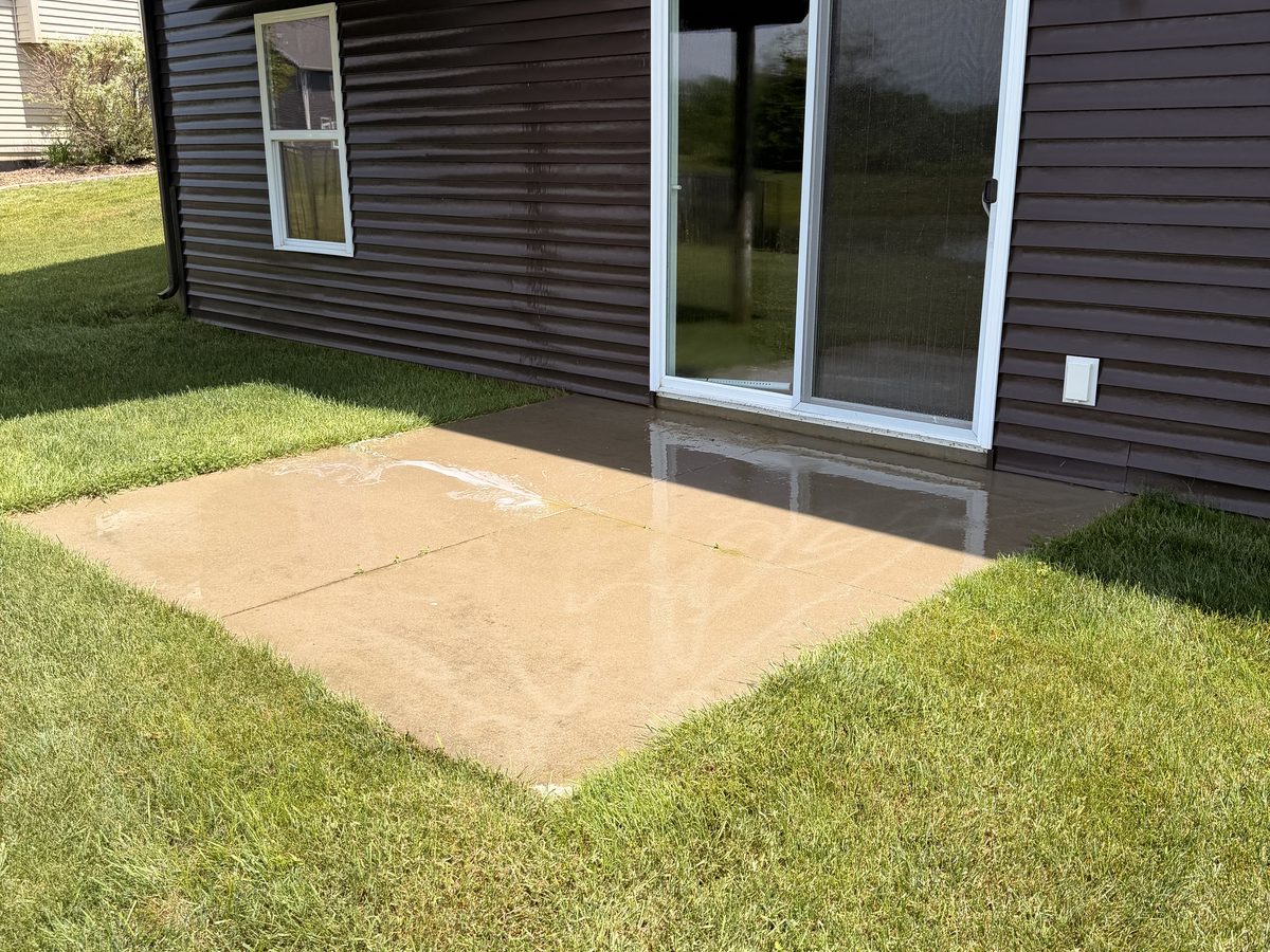 Dirty, streaked concrete patio before pressure washing